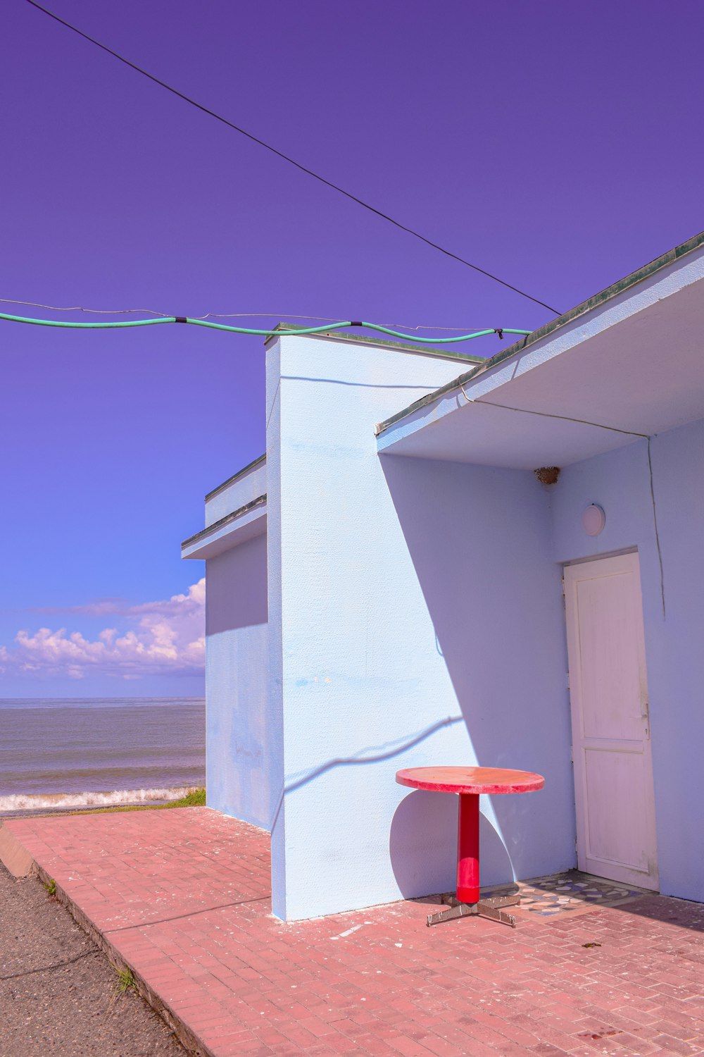 red and white outdoor chair near white concrete building during daytime