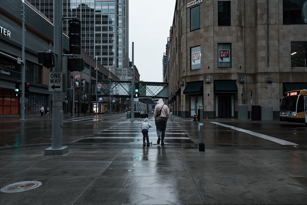 man in black jacket and blue denim jeans walking on sidewalk during daytime