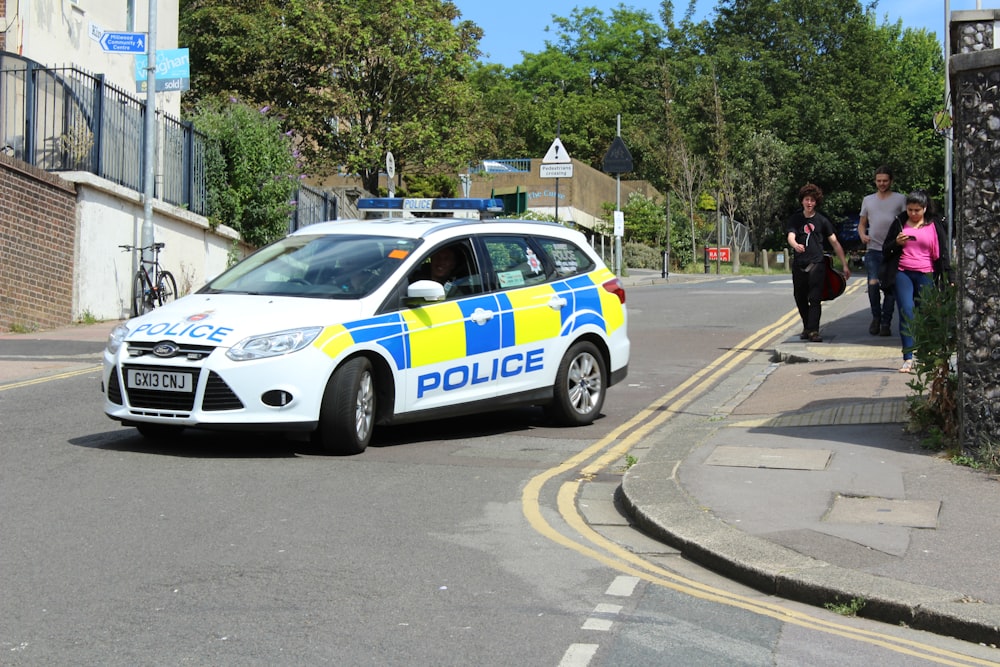 white and blue police car on road during daytime