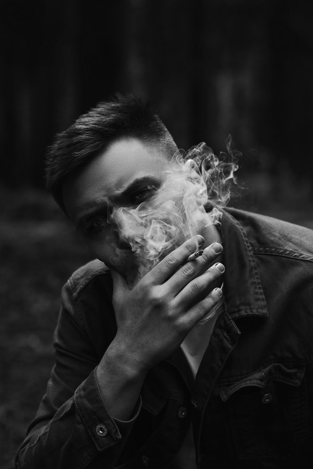 man in black leather jacket smoking cigarette