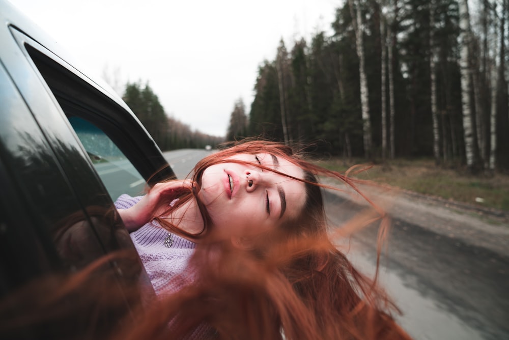 woman in black framed eyeglasses driving car during daytime