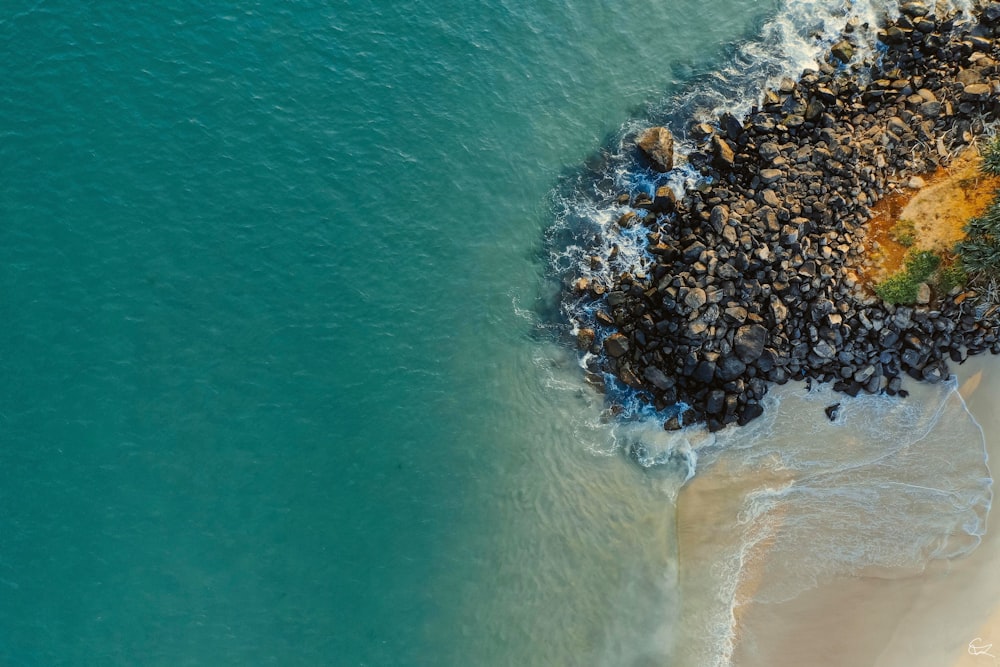 aerial view of sea waves crashing on shore during daytime