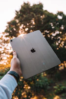 person holding silver apple macbook