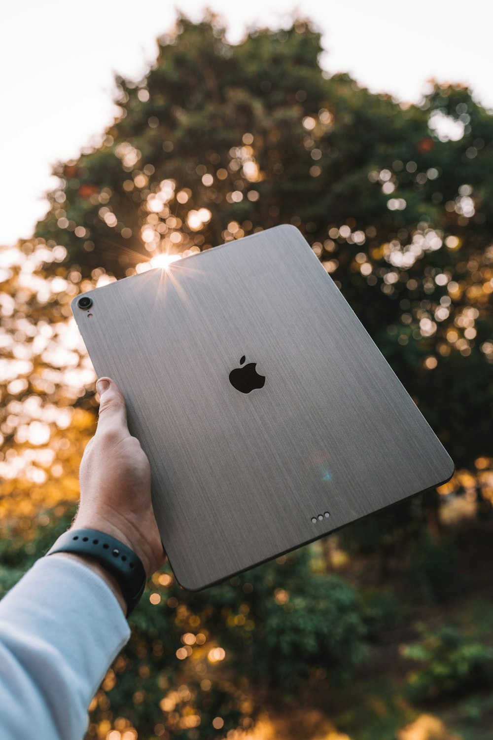 Personne tenant un MacBook Apple argenté