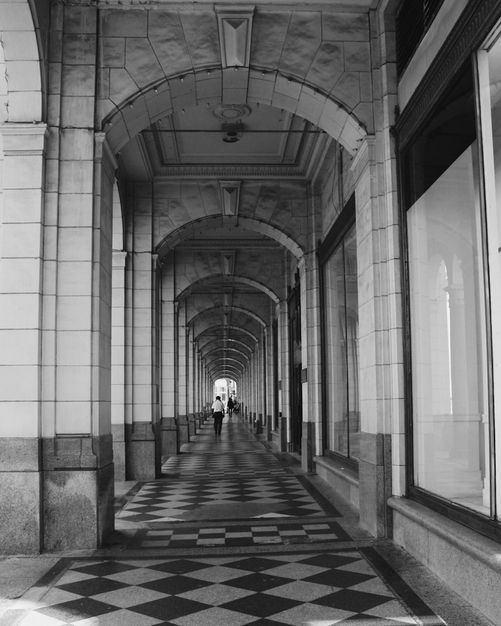 grayscale photo of hallway with glass windows