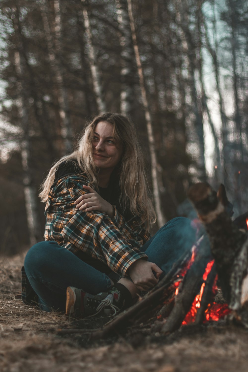 woman in blue denim jeans sitting on ground beside brown dog during daytime