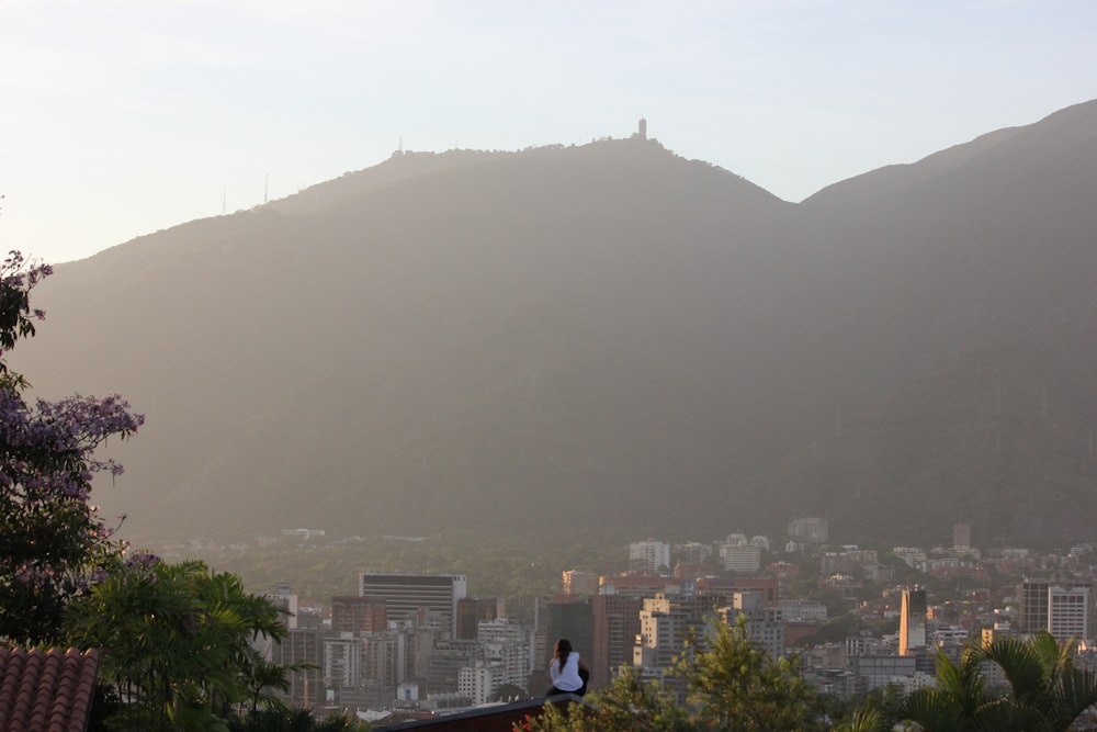Persona con chaqueta azul de pie en la cima de la montaña durante el día