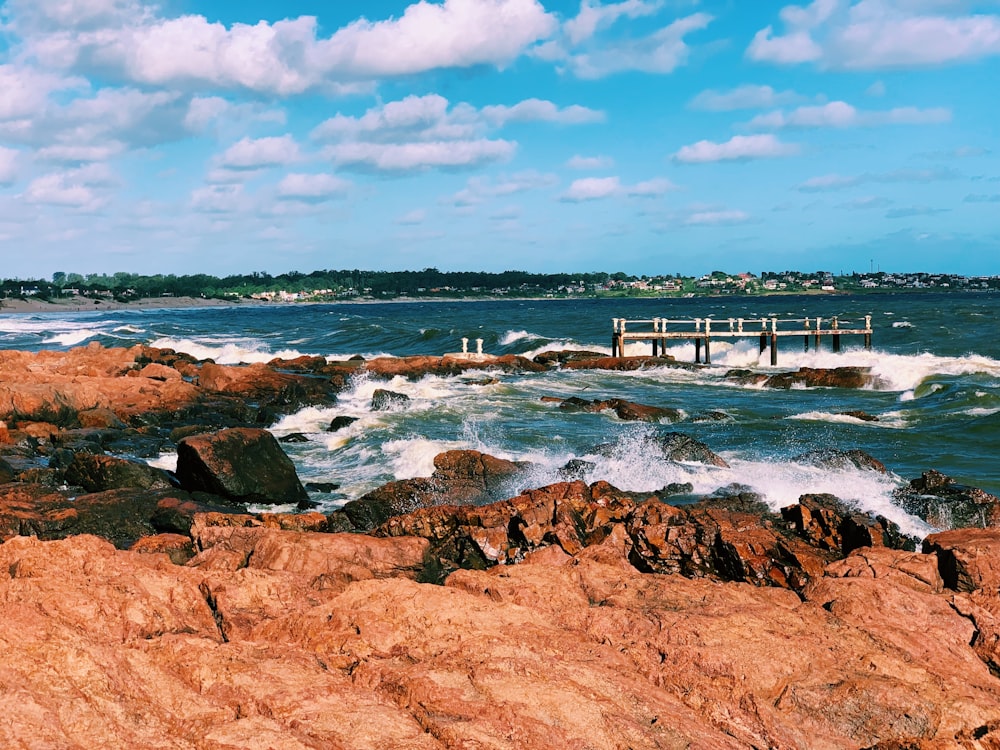 brown wooden dock on sea under blue sky during daytime