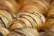 Golden, flaky pastries drizzled with dark chocolate are arranged in close proximity. The pastries have a delicate, layered texture that is visually appetizing.