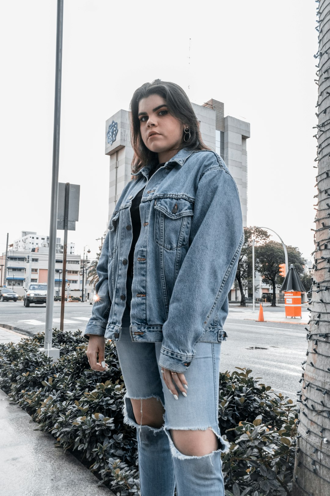 woman in blue denim jacket standing on the street during daytime