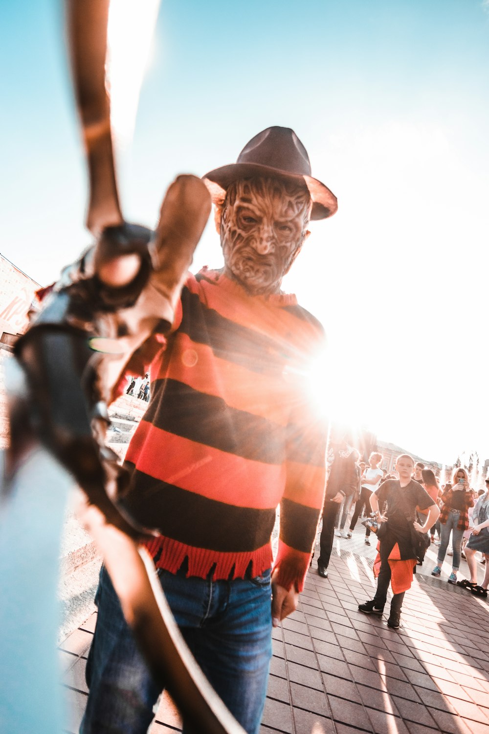 man in orange and white stripe shirt wearing black cowboy hat