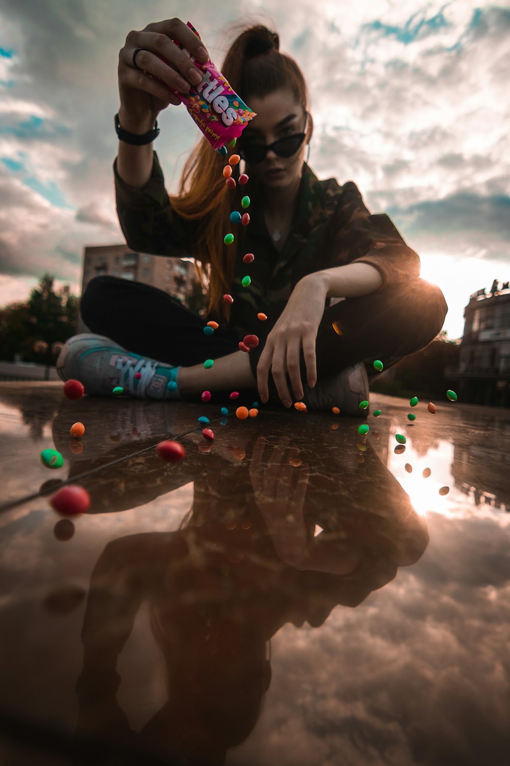 woman in black jacket and blue denim jeans sitting on the floor with water droplets