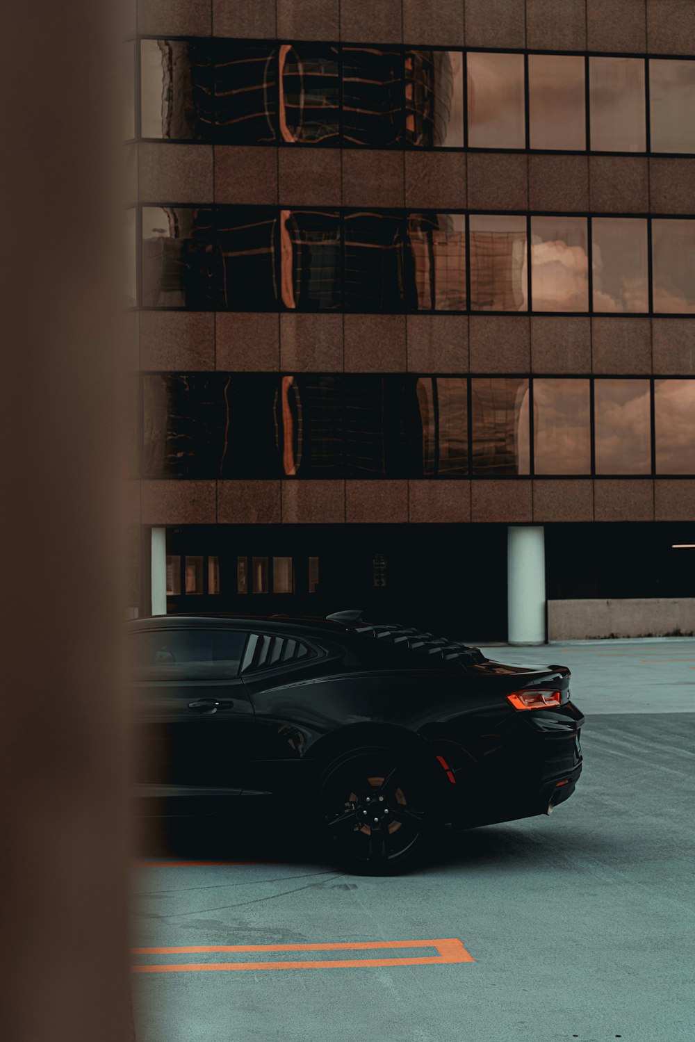 Schwarzes Auto neben braunem Gebäude geparkt