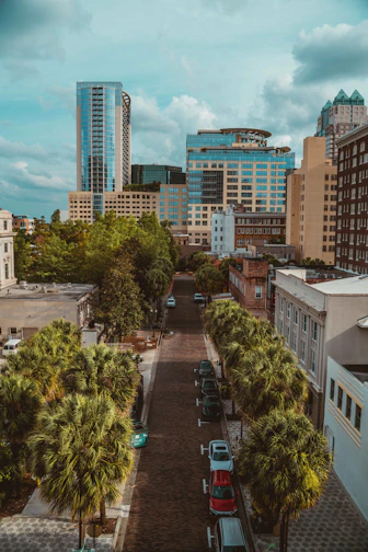 cars parked on parking lot near high rise buildings during daytime