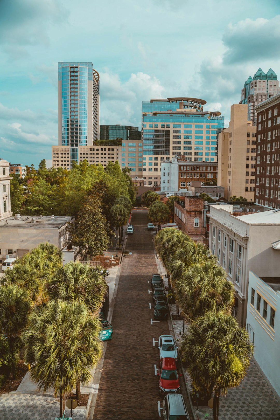 cars parked on parking lot near high rise buildings during daytime