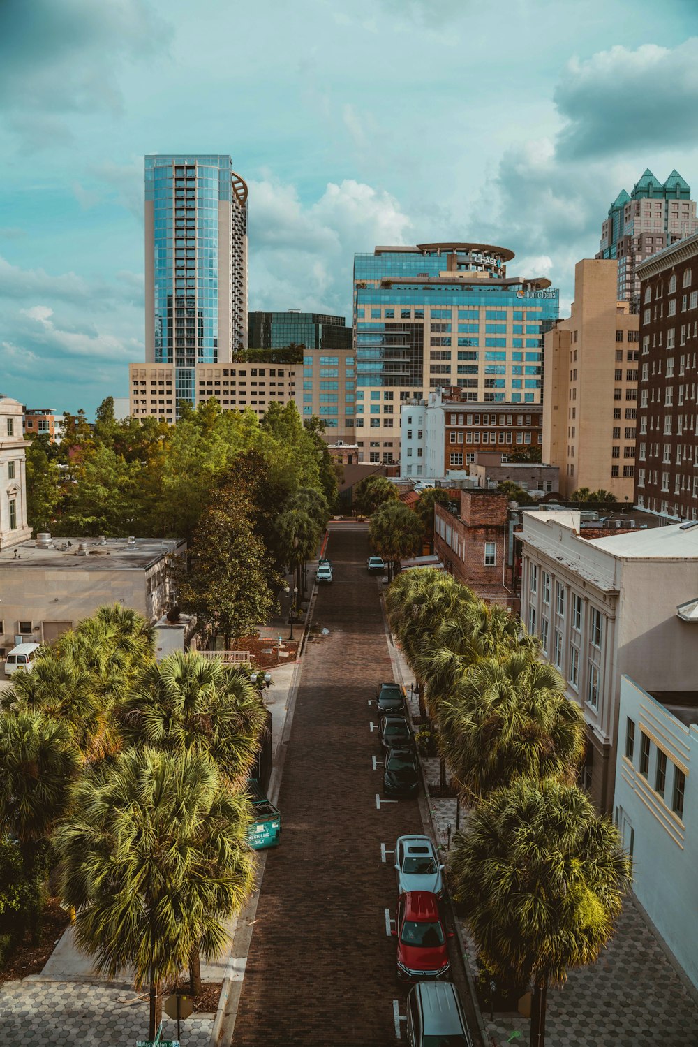 cars parked on parking lot near high rise buildings during daytime