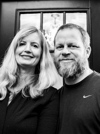 Portrait of Dr. Anna-Christina Bernd and Dr. Richard Brodnig smiling in their modern clinic.