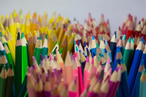 A vibrant shot showing a set of colorful pencils arranged neatly on a rustic wooden table.