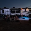 people sitting on chair near white and blue tent during night time