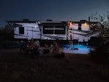 people sitting on chair near white and blue tent during night time