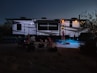 people sitting on chair near white and blue tent during night time