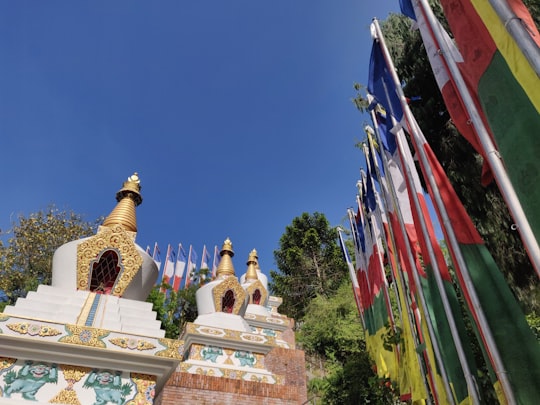 gold and white buddha statue under blue sky during daytime in Kapan Nepal