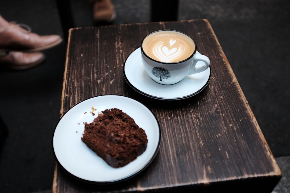 white ceramic cup with cappuccino on white ceramic saucer