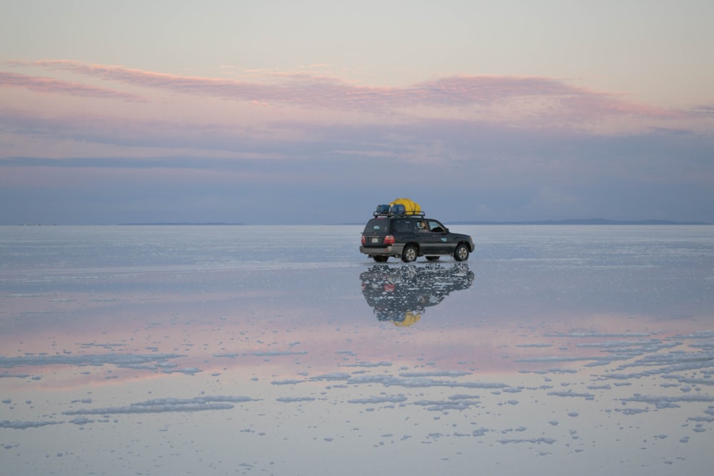 black suv on beach during sunset