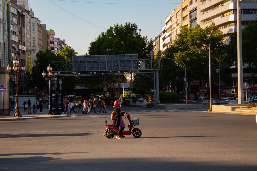 man in red and black jacket riding on red and black motorcycle on road during daytime