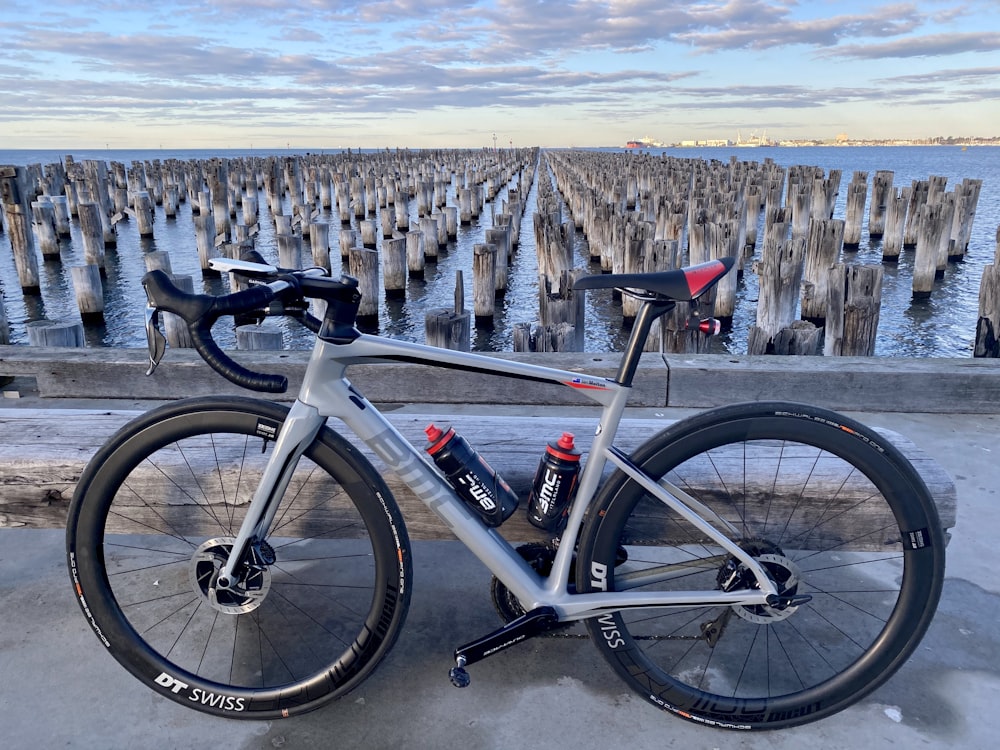 black and white mountain bike on gray wooden fence during daytime