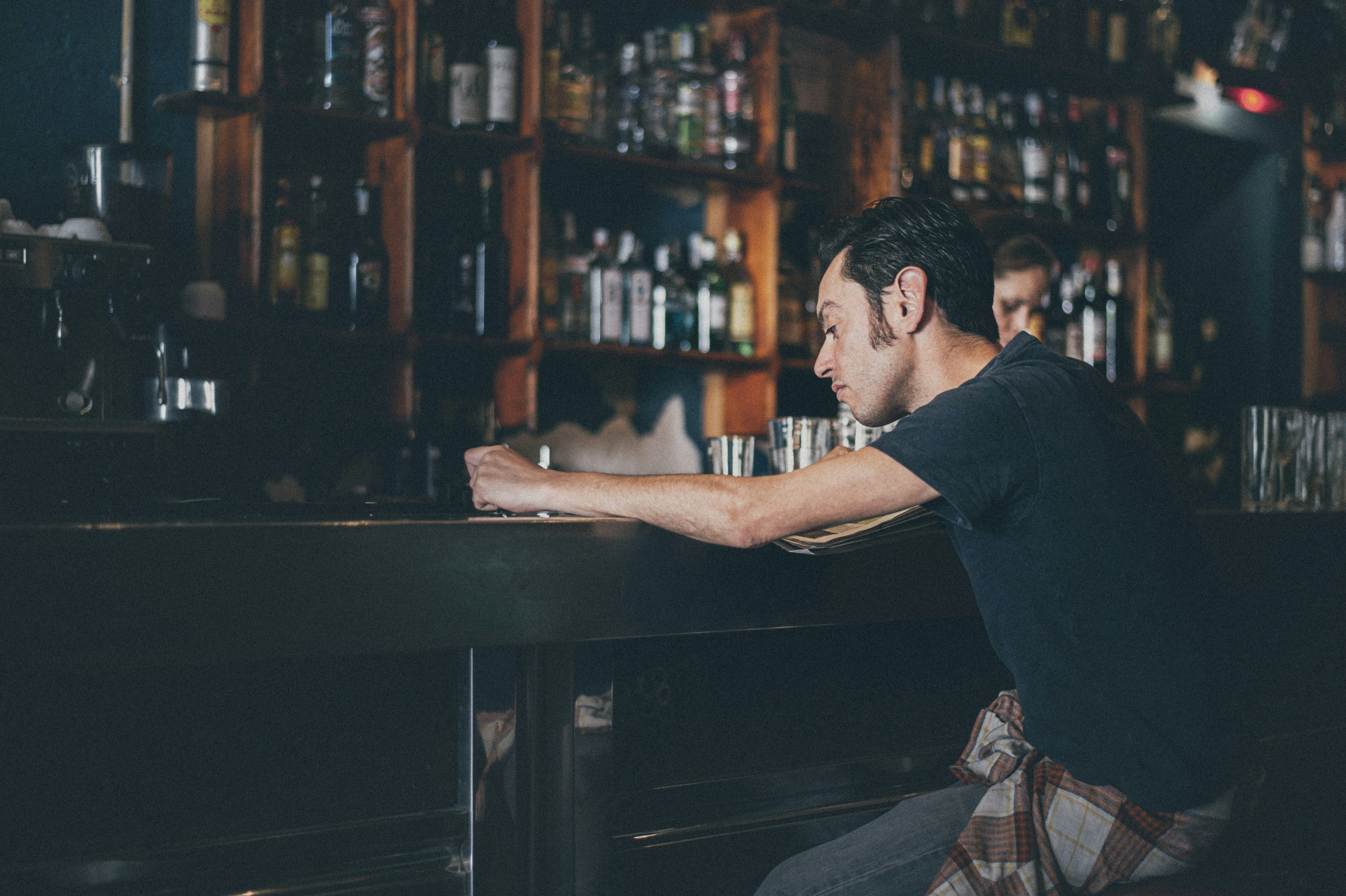 A man reads the morning paper in a bar.