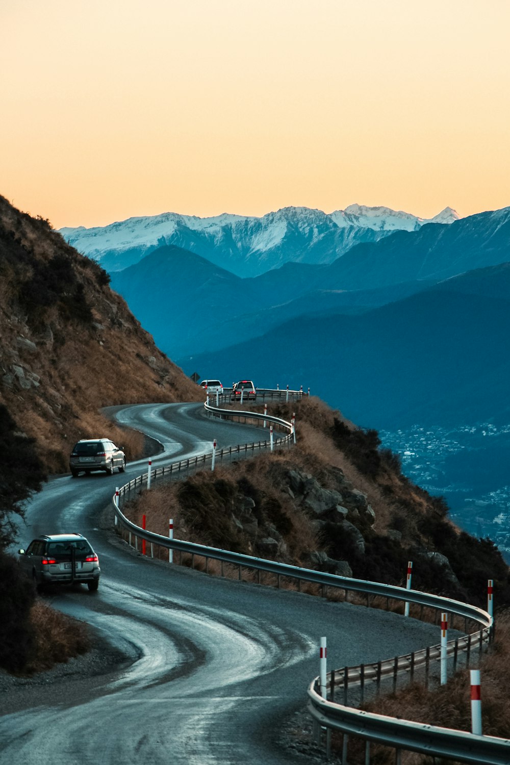 cars on road near mountain during daytime