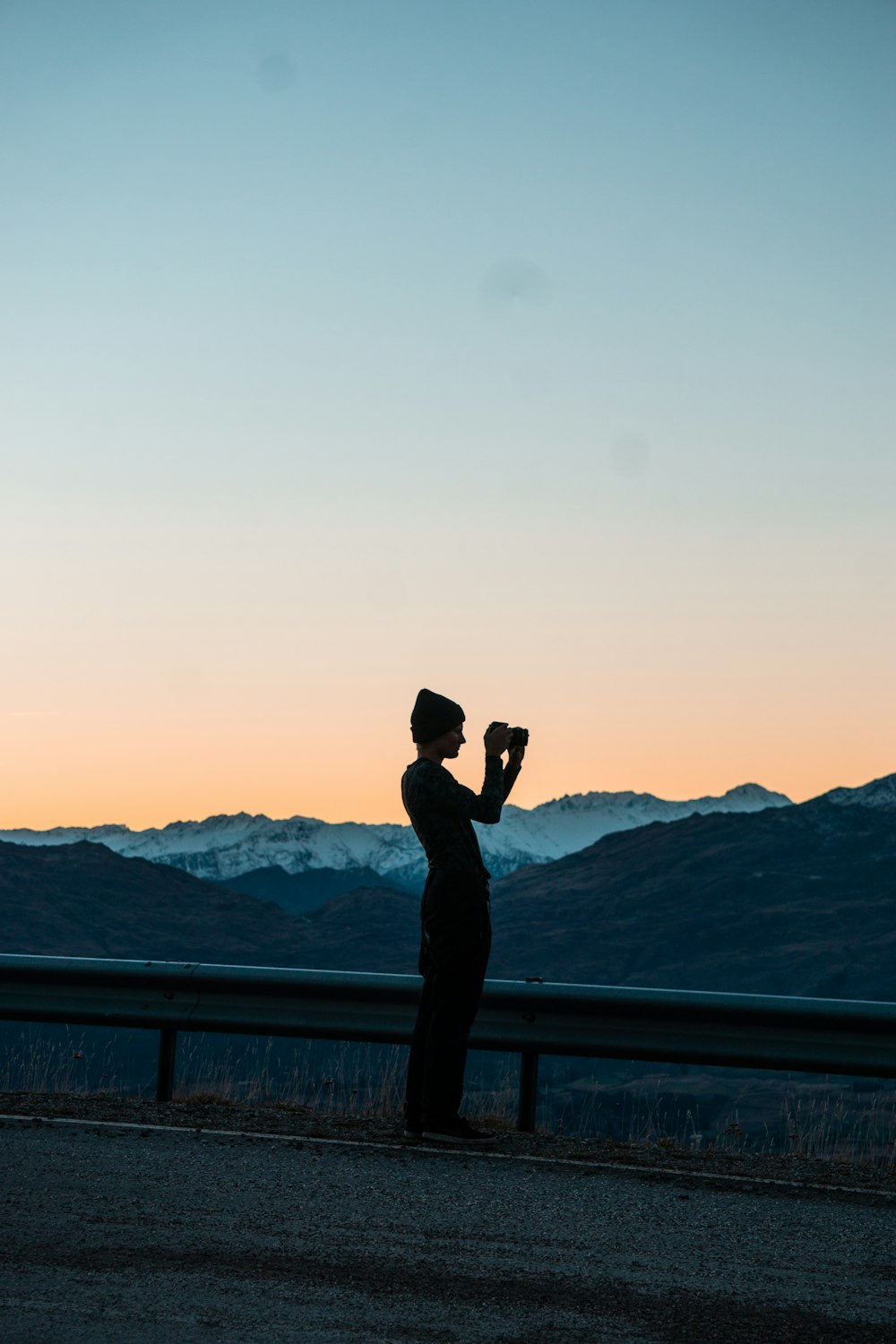 man in black jacket standing on top of the mountain during daytime