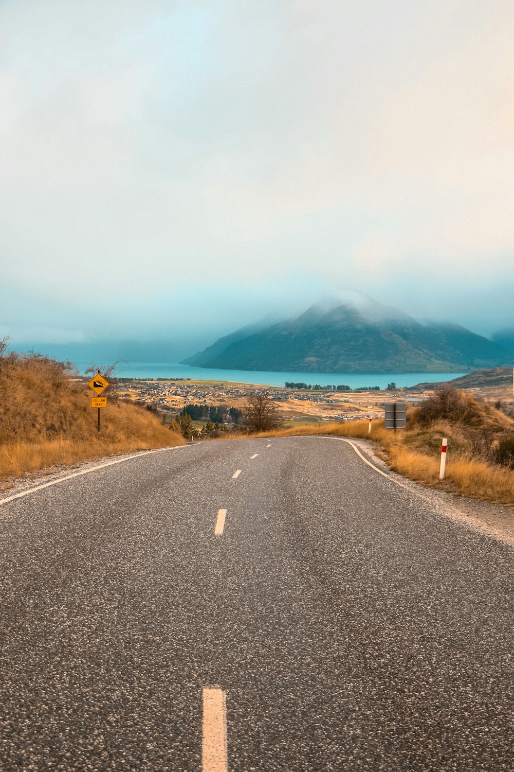 gray concrete road near mountain during daytime