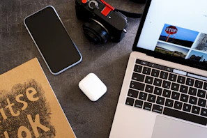 A flat lay of a laptop, headphones, and a Descarga Viva e-book open on screen.