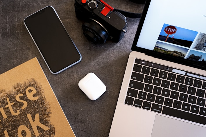 A vibrant flat lay of a laptop, notebook, and headphones representing digital learning tools.