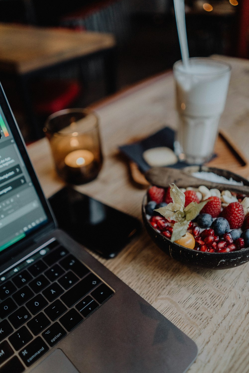 sliced strawberries on black bowl beside macbook pro