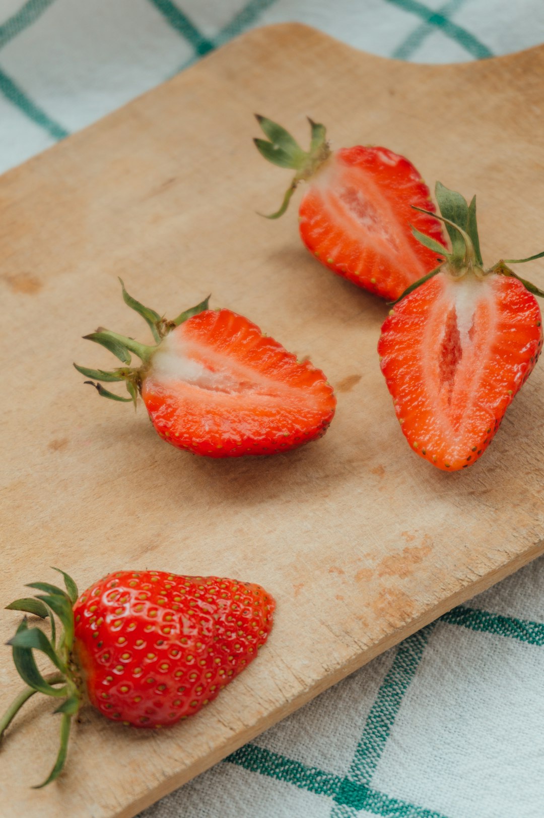 sliced strawberries on brown wooden chopping board