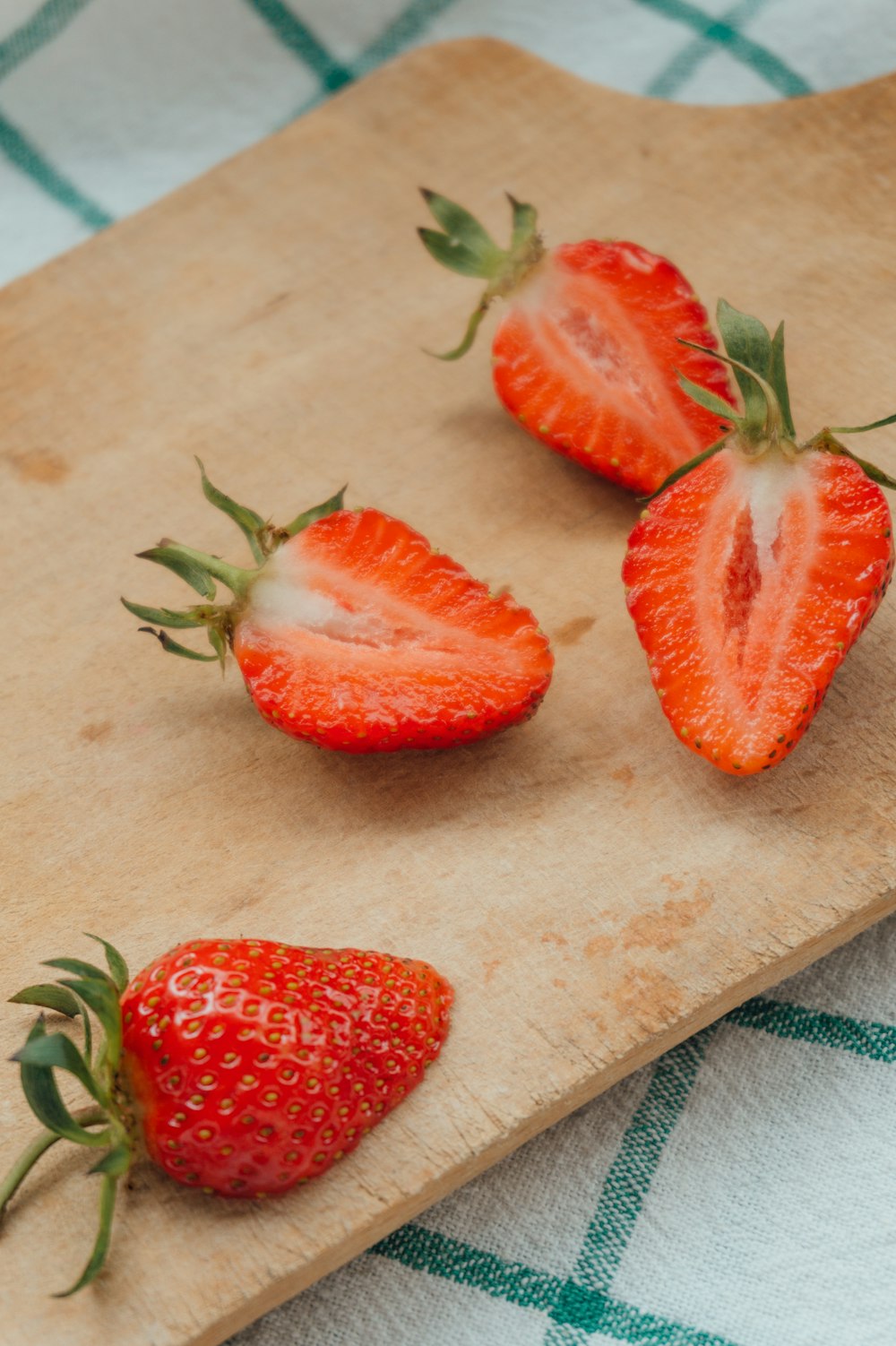 sliced strawberries on brown wooden chopping board