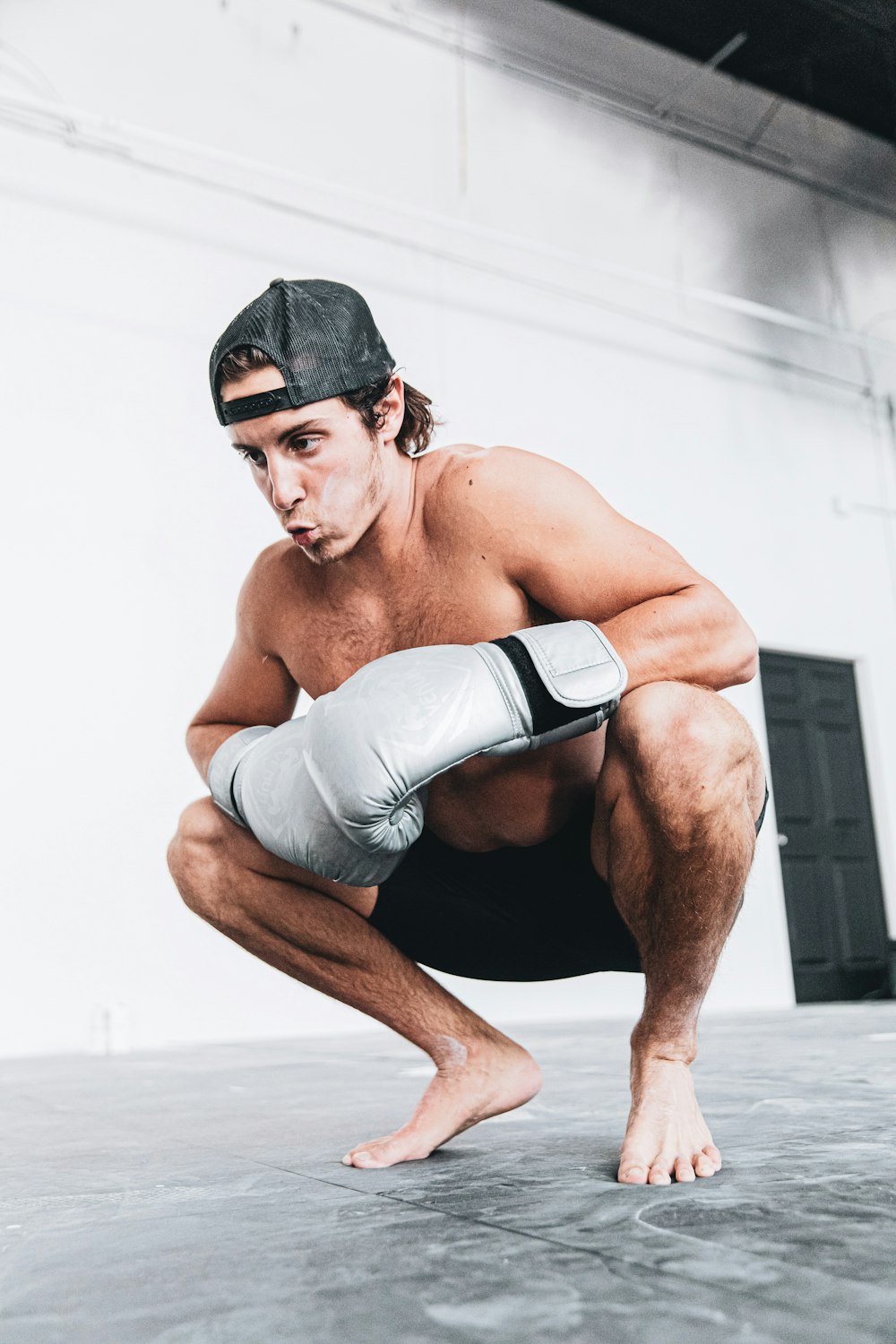 topless man in gray shorts sitting on floor