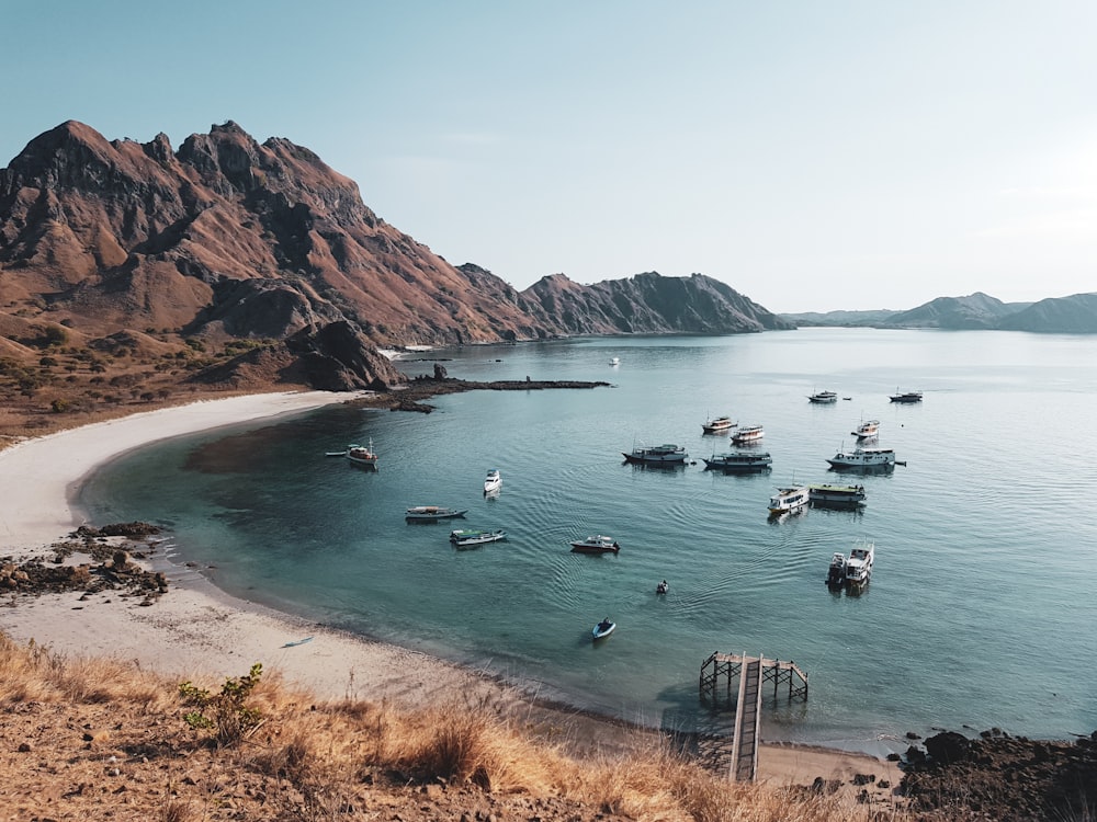 boats on sea near mountain during daytime