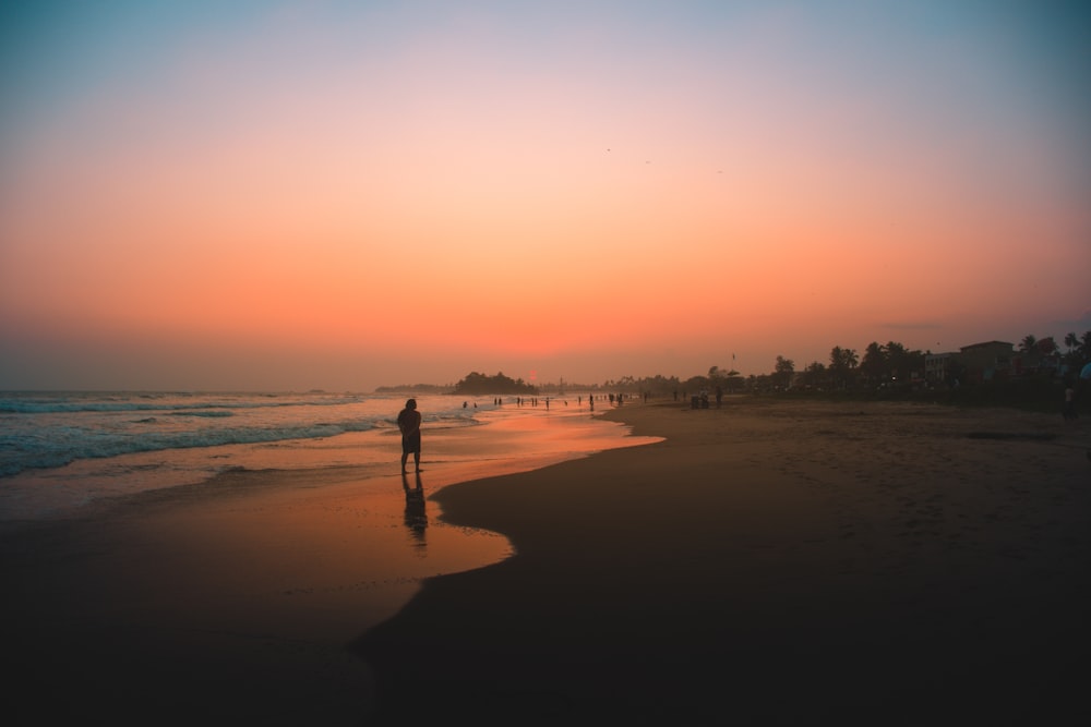 silhouette of people on beach during sunset