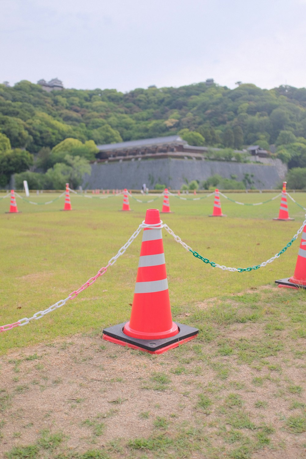 red and white striped traffic cone on green grass field during daytime