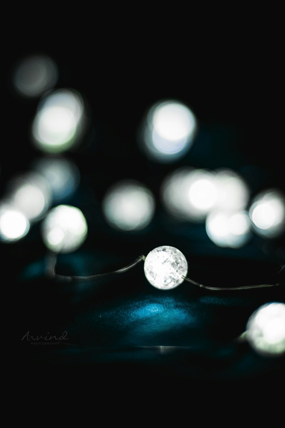 silver round pendant necklace on black surface