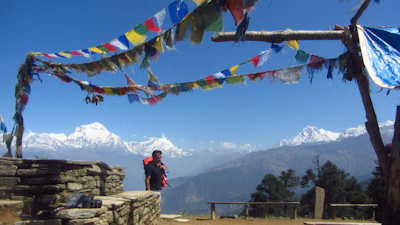 Pilgrims stepping onto the heli-pad with backpacks and prayer flags fluttering