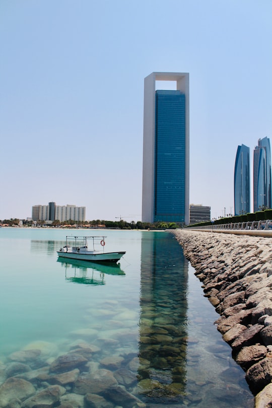 white boat on water near city buildings during daytime in Emirates Heritage Club Heritage Village United Arab Emirates