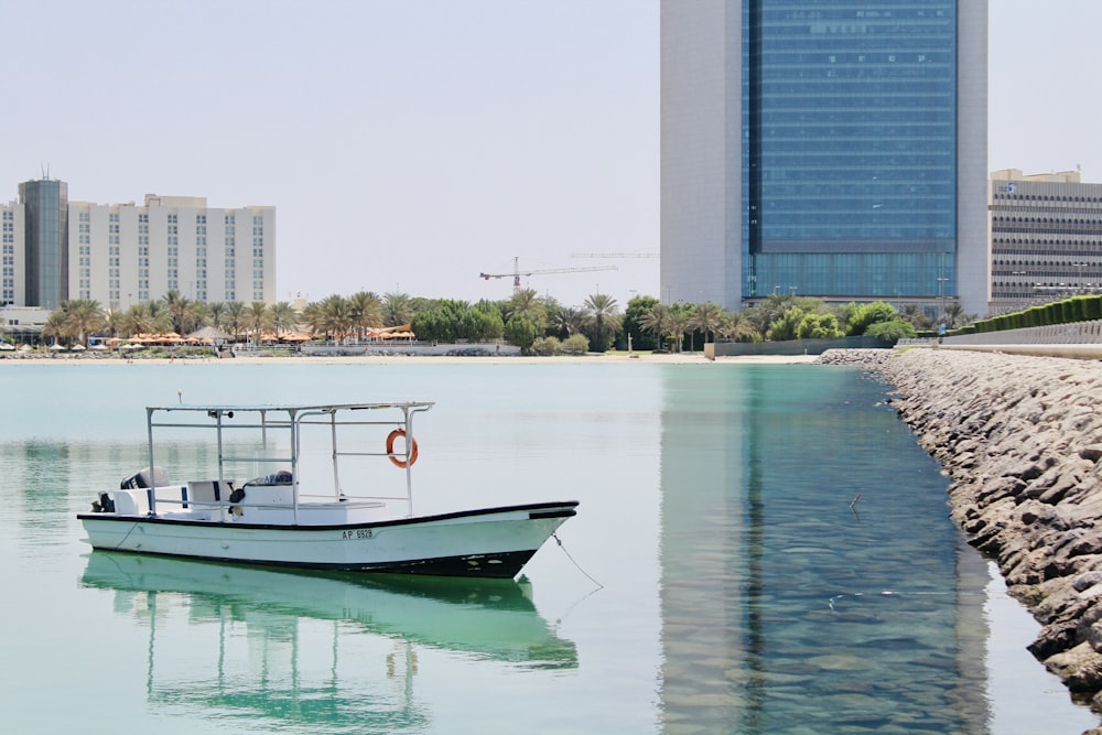 white and red boat on water near building during daytime