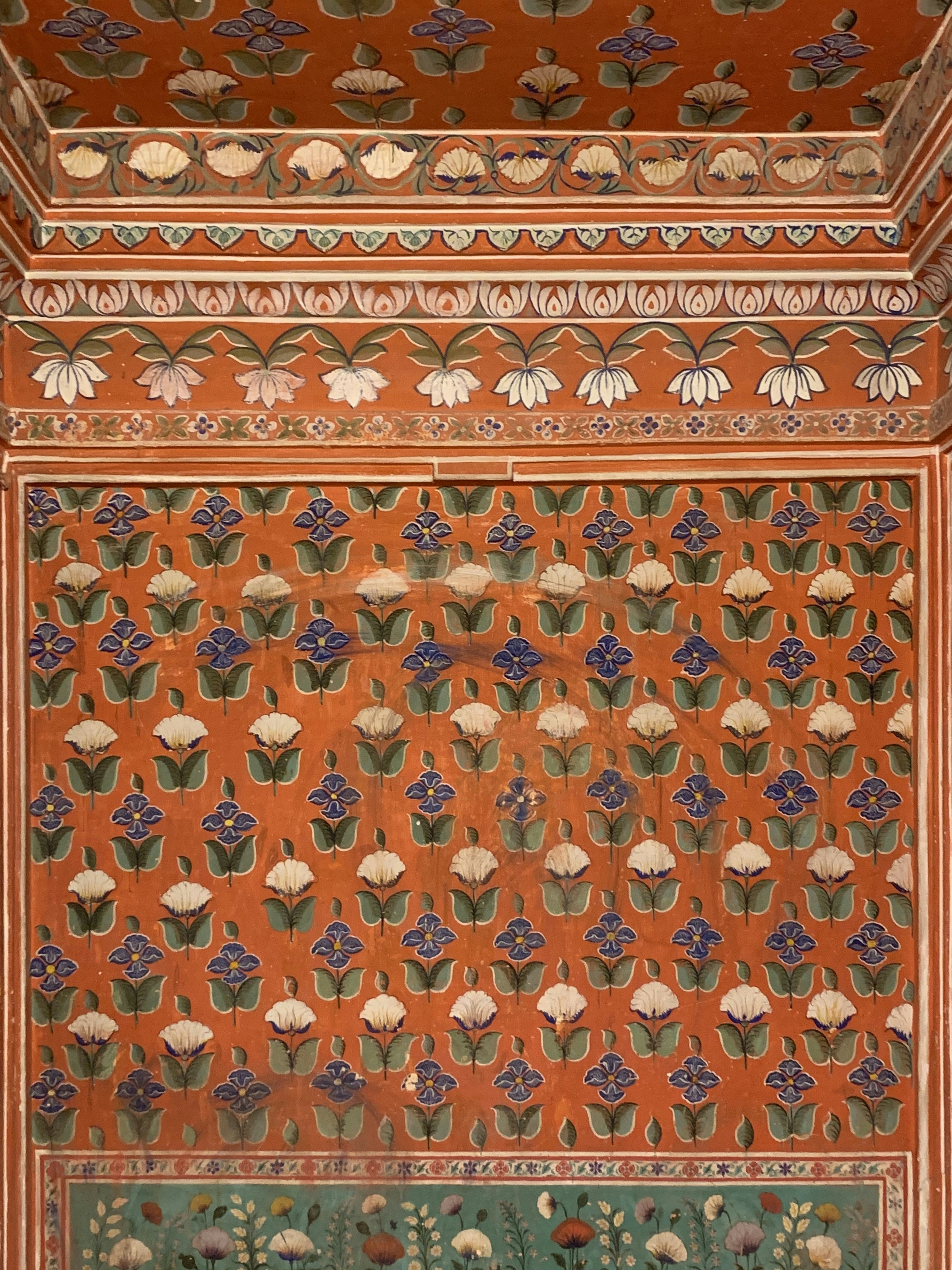 a painting of flowers and leaves on a wall