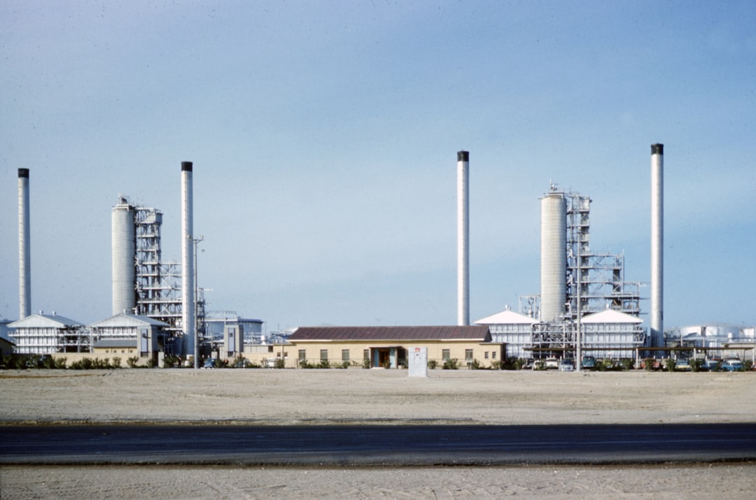 white and brown factory under blue sky during daytime