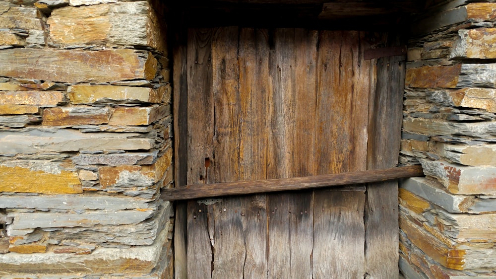 Porta in legno marrone con muro di mattoni bianchi